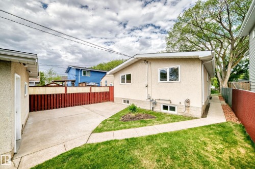 Exterior stucco finish, concrete driveway, concrete walkway, and a red wooden fence - 12022 62 Street, Edmonton, AB 