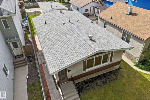 Ranch-style residence featuring a gray shingle roof, a two-tone stucco exterior, and a manicured front lawn - 12022 62 Street, Edmonton, AB 