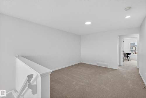 Carpeted open area featuring neutral wall tones, recessed lighting, and white trim - 17023 45 Street, Edmonton, AB 
