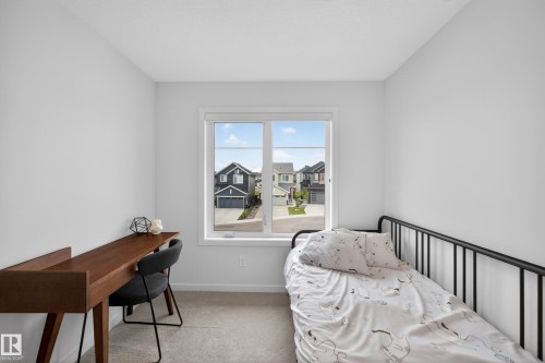 Bright interior room with a large window, light gray carpet, and white painted walls - 17023 45 Street, Edmonton, AB 