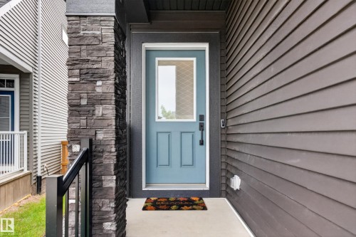 Front entry featuring a light blue door with a clear glass insert - 17023 45 Street, Edmonton, AB 