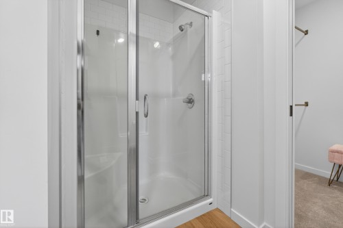 Enclosed shower with clear glass sliding door, polished chrome hardware, and white subway tile surround - 17023 45 Street, Edmonton, AB 