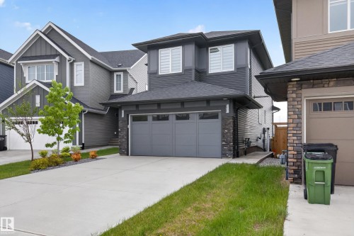 Modern two-story residence featuring a dark gray siding exterior with stone accent columns - 17023 45 Street, Edmonton, AB 