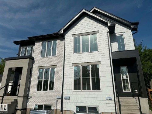 Contemporary multi-level exterior featuring light-toned brick and shingle siding, a dark trim package, and multiple large windows - 10985 130 Street, Edmonton, AB 
