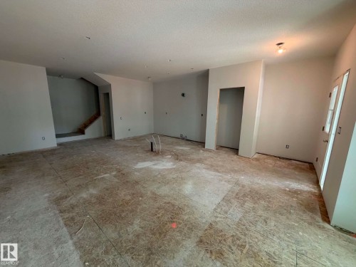 Spacious interior framing, unfinished subflooring, and a visible staircase - 10985 130 Street, Edmonton, AB 