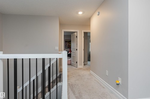 Upper level hallway featuring light gray wall paint and light gray carpet - 8744 223 Street Nw, Edmonton, AB 