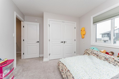 2nd Bedroom featuring light gray wall paint, white trim, and light gray carpeting - 8744 223 Street Nw, Edmonton, AB 