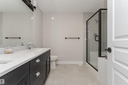 Double vanity with a light-toned countertop and dark wood-finish cabinetry - 8744 223 Street Nw, Edmonton, AB 