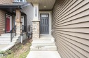 Contemporary entry with a dark gray paneled door and frosted glass insert - 8744 223 Street Nw, Edmonton, AB 