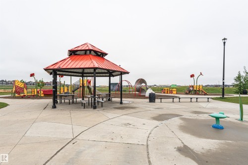 Community park featuring a red-roofed gazebo, concrete pathways, a splash pad, a children's play structure, and ample green space - 8744 223 Street Nw, Edmonton, AB 