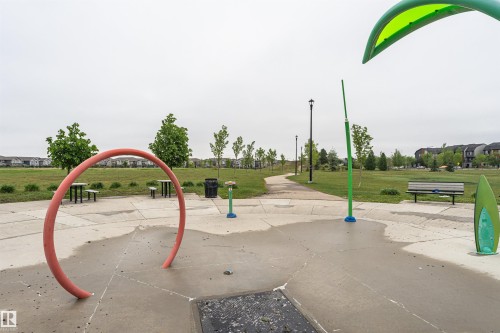 Community splash pad featuring interactive water features, concrete surfacing, and surrounding green space - 8744 223 Street Nw, Edmonton, AB 