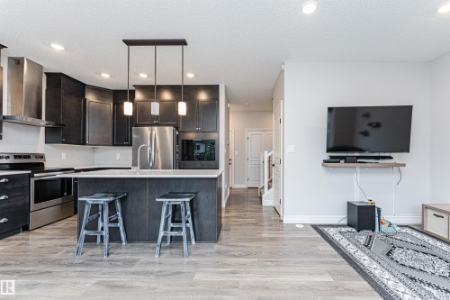 Open-concept living space with wood-finish flooring - 8744 223 Street Nw, Edmonton, AB 