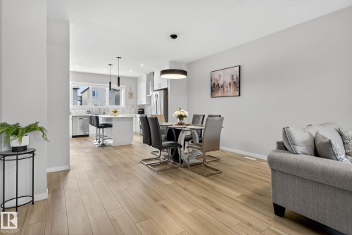 Open-concept living space featuring wood-finish flooring, recessed lighting, and a neutral color palette - 1213 16A Street, Edmonton, AB 