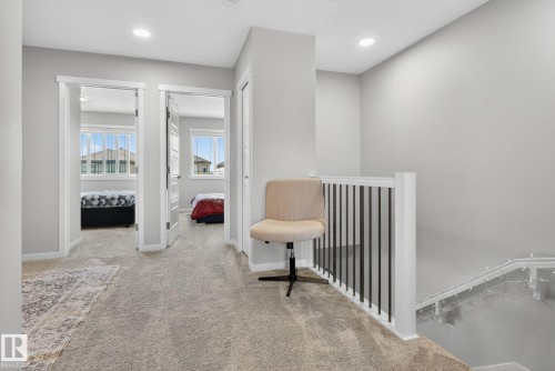 Upper-level landing featuring light gray walls, plush carpeting, recessed lighting, and white trim - 1213 16A Street, Edmonton, AB 