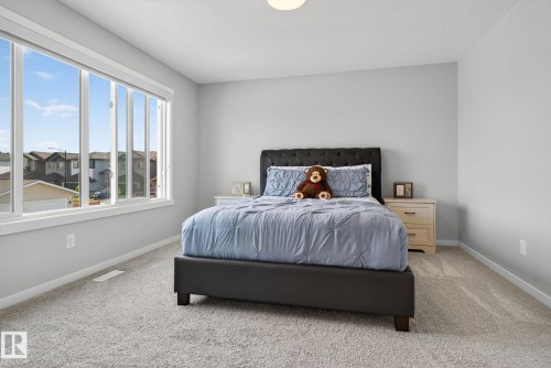 Spacious room featuring a large multi-pane window, neutral wall paint, and light-toned carpeting - 1213 16A Street, Edmonton, AB 