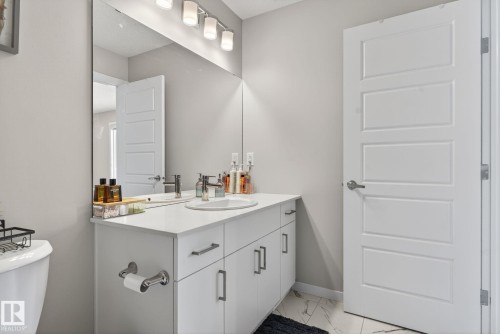 Modern bathroom vanity with a white countertop, undermount sink, and chrome faucet - 1213 16A Street, Edmonton, AB 
