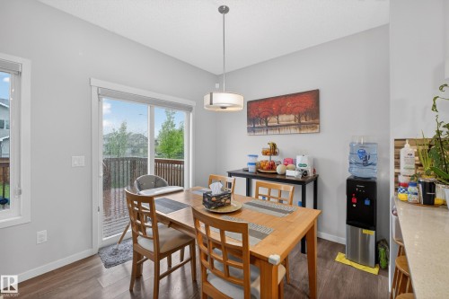 Dining area featuring wood-finish flooring and a contemporary pendant light fixture - 1404 25 Avenue, Edmonton, AB 