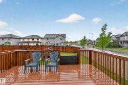 Spacious wood-finish deck with railing overlooking a fenced yard - 
