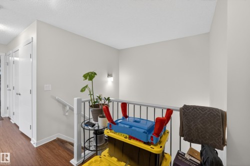 Upper landing featuring wood-finish flooring, white walls, and a recessed ceiling light - 1404 25 Avenue, Edmonton, AB 