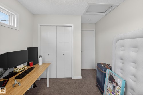 Room featuring neutral wall paint, textured ceiling, a double bi-fold closet, and a white interior door - 1404 25 Avenue, Edmonton, AB 