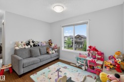 Bright interior room featuring a large window with white trim, wood-finish flooring, and light-toned walls - 