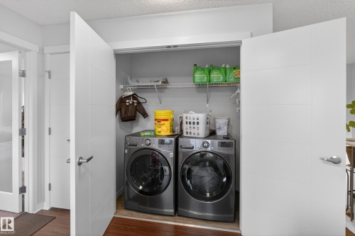Dedicated laundry closet featuring a built-in wire shelf, hanging rod, and wood-finish flooring - 1404 25 Avenue, Edmonton, AB 