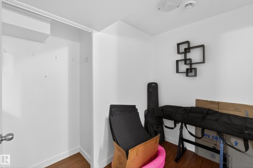 Spacious interior room featuring wood-finish flooring, white walls, and a built-in closet with a white door - 1404 25 Avenue, Edmonton, AB 