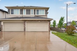 Contemporary property exterior featuring a two-car garage with individual doors, a concrete driveway, and a stone accent facade - 