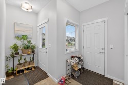Entryway featuring light gray walls, a flush-mount ceiling light fixture, and wood-finish flooring - 