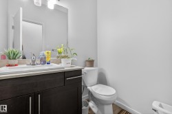 Bathroom featuring a dark wood-finish vanity with chrome hardware, an integrated sink, and light countertop - 
