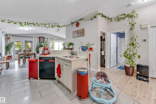 Kitchen featuring light-toned cabinetry, a black dishwasher, and a light-colored countertop - 3519 22 Street Nw, Edmonton, AB 
