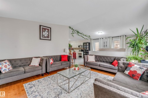 Open-concept living area featuring hardwood flooring, a decorative area rug, and recessed lighting - 3519 22 Street Nw, Edmonton, AB 