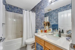 Bathroom featuring a white bathtub, toilet, and a vanity with a light-colored countertop - 