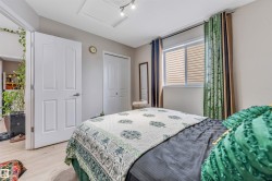 Interior room featuring light wood-finish flooring, a white paneled door, and a horizontal window with blinds - 