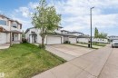 White two-story residence featuring an attached garage with a white sectional door - 3519 22 Street Nw, Edmonton, AB 