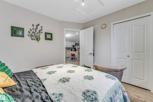 Bedroom featuring neutral wall paint, wood-finish flooring, and white bi-fold closet doors - 3519 22 Street Nw, Edmonton, AB 