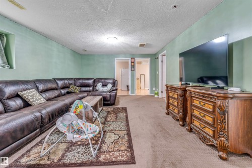 Spacious carpeted room featuring light green walls and multiple doorways - 3519 22 Street Nw, Edmonton, AB 