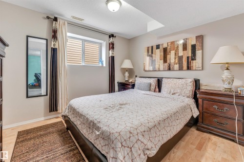 Interior room featuring light wood-finish flooring, a window with horizontal blinds, and neutral-toned walls - 3519 22 Street Nw, Edmonton, AB 