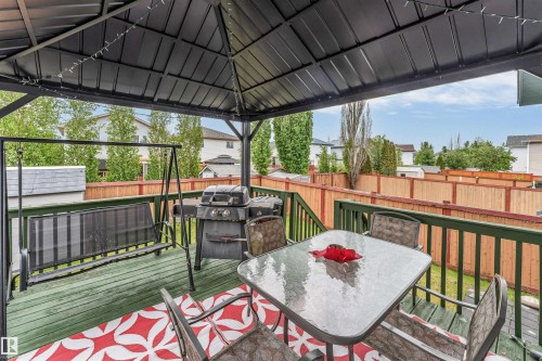 Expansive outdoor deck featuring a dark metal gazebo, green wood-finish decking, and a wood privacy fence - 3519 22 Street Nw, Edmonton, AB 