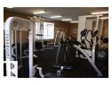 Fitness center featuring multiple exercise machines, textured dark carpeting, beige wall tones, and recessed lighting - 425 4304 139 Avenue, Edmonton, AB 