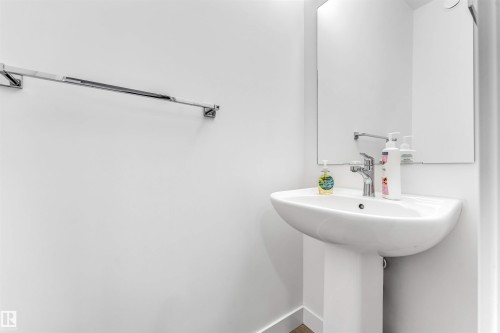 Pedestal sink with chrome faucet, framed mirror, and chrome towel bar - 45 2710 66 Street, Edmonton, AB 