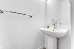 Pedestal sink with chrome faucet, framed mirror, and chrome towel bar - 