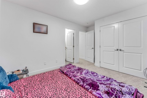 Bedroom featuring a neutral carpet, white walls, and a semi-flush ceiling light - 45 2710 66 Street, Edmonton, AB 