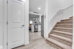 Carpeted staircase with white handrail, leading to an upper level - 