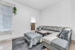 Bright room featuring light wood-finish flooring, white walls, and a white baseboard trim - 