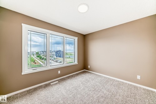 Expansive window featuring decorative grilles, white trim, and a surrounding neighborhood landscape - 1210 Stoneside Road, Sherwood Park, AB - Indoor Photo Showing Other Room