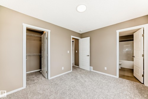 Carpeted interior room with neutral-toned walls, white trim, and a ceiling-mounted light fixture - 1210 Stoneside Road, Sherwood Park, AB - Indoor