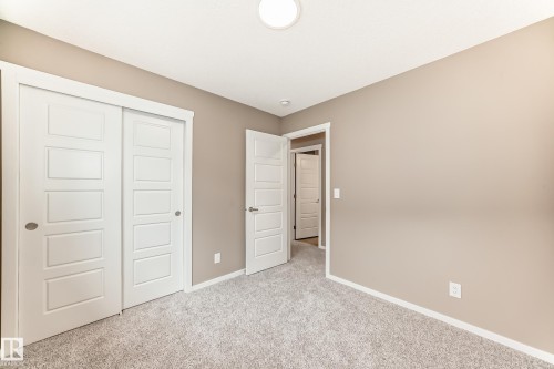 Neutral-toned room featuring a flush-mount ceiling light, white trim, and light gray carpeting - 1210 Stoneside Road, Sherwood Park, AB - Indoor Photo Showing Other Room
