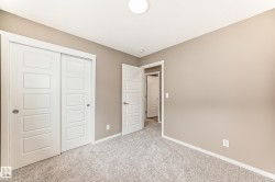 Neutral-toned room featuring a flush-mount ceiling light, white trim, and light gray carpeting - 
