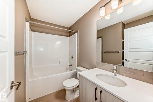 Bathroom featuring a vanity with a white countertop, an undermount sink, and wood-finish cabinetry - 1210 Stoneside Road, Sherwood Park, AB - Indoor Photo Showing Bathroom